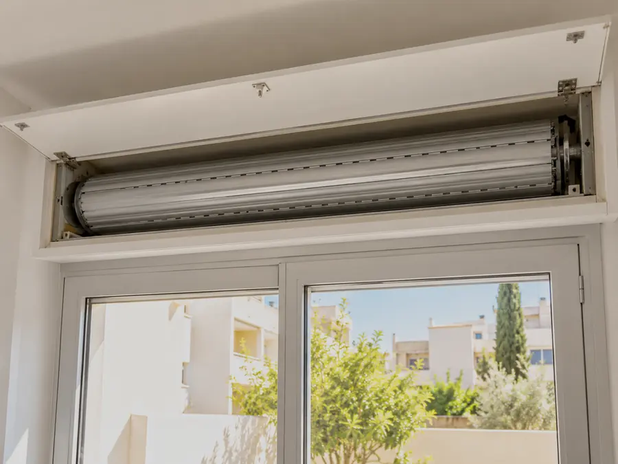 Tapa de calaix interior oberta amb l’eix d’una persiana enrotllable a la vista